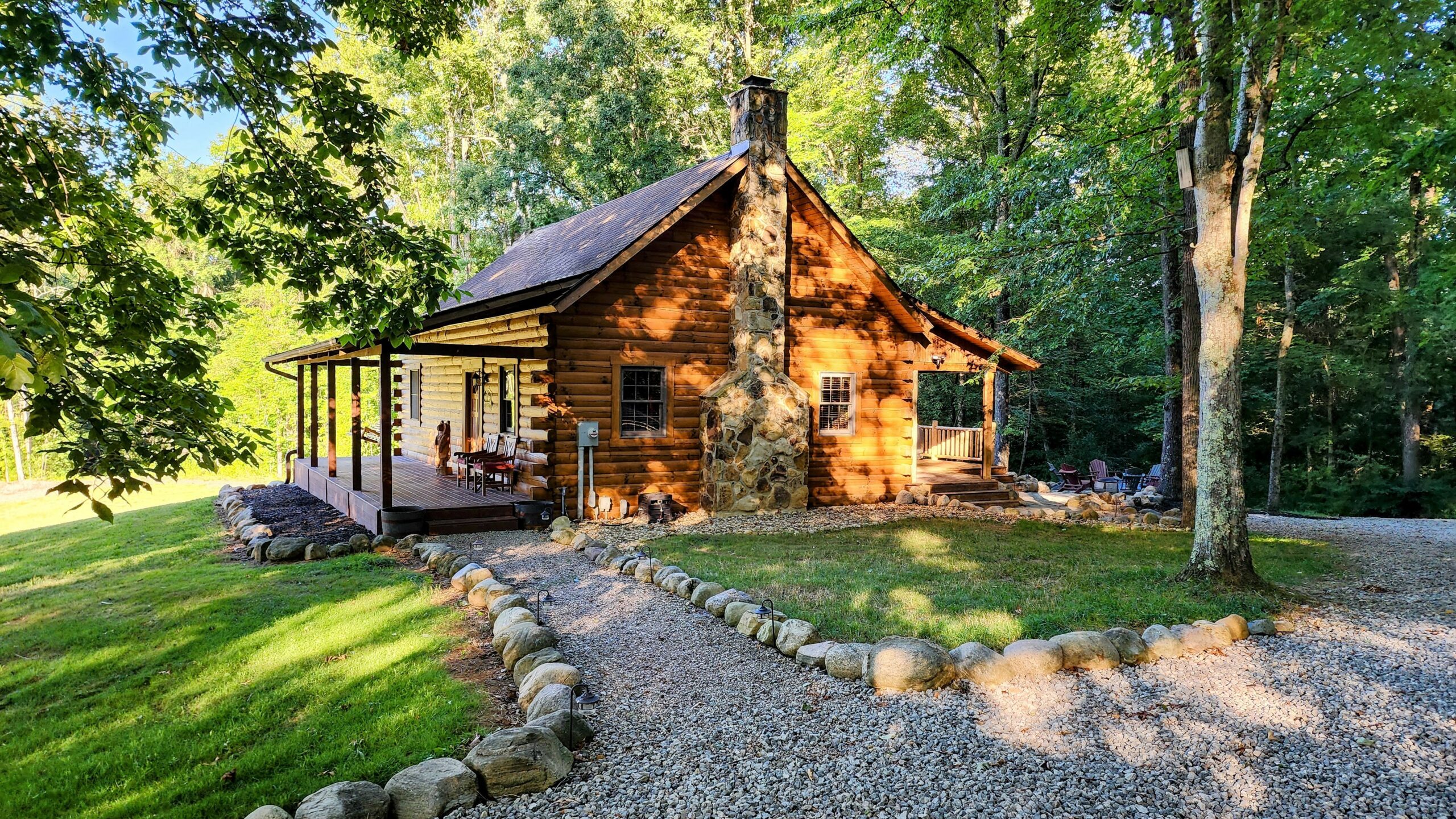 Secluded cabin rental near Hocking Hills Ohio surrounded by woods with outdoor deck, fire pit, and Adirondack seating
